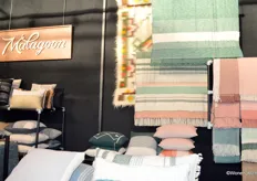 Nieuwe voorjaarskleuren en materialen in de stand van Malagoon, een verzameling quilts, kussens, vloerkleden, stoelen en accessoires.